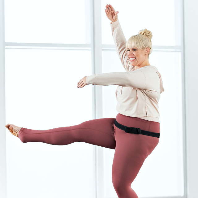 A woman instucts an at home family barre class with Life Time Classes On Demand