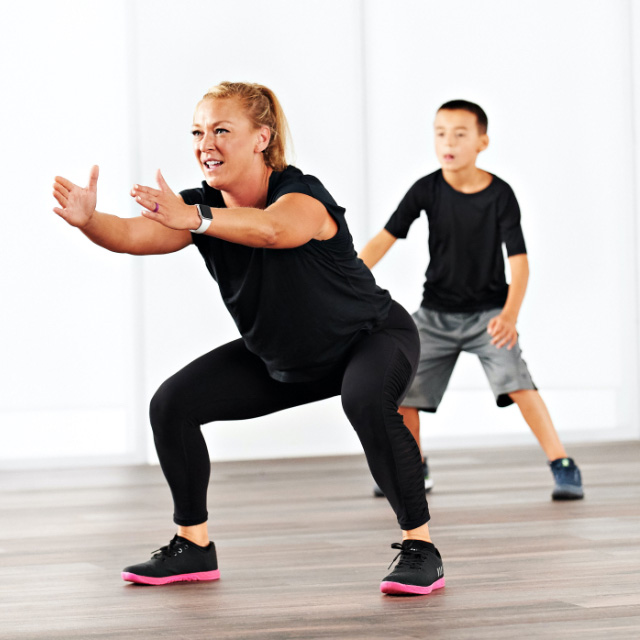 A family taking a hit class at home with Life Time Classes On Demand