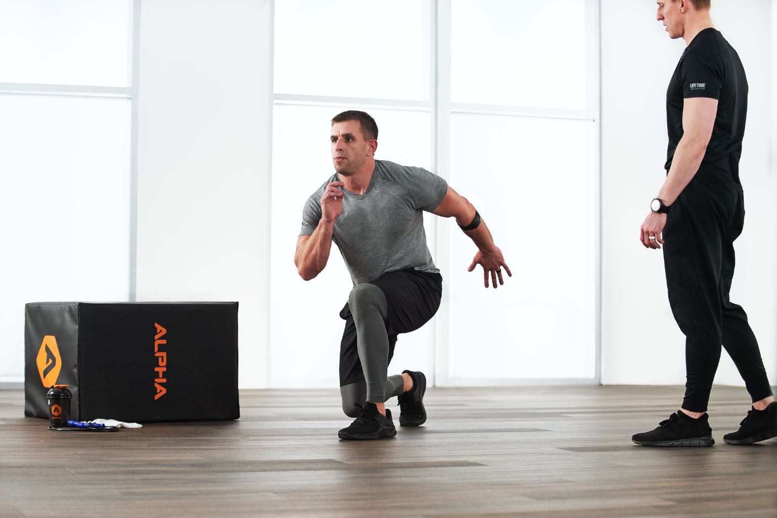 an alpha coach instructs an athlete lunging