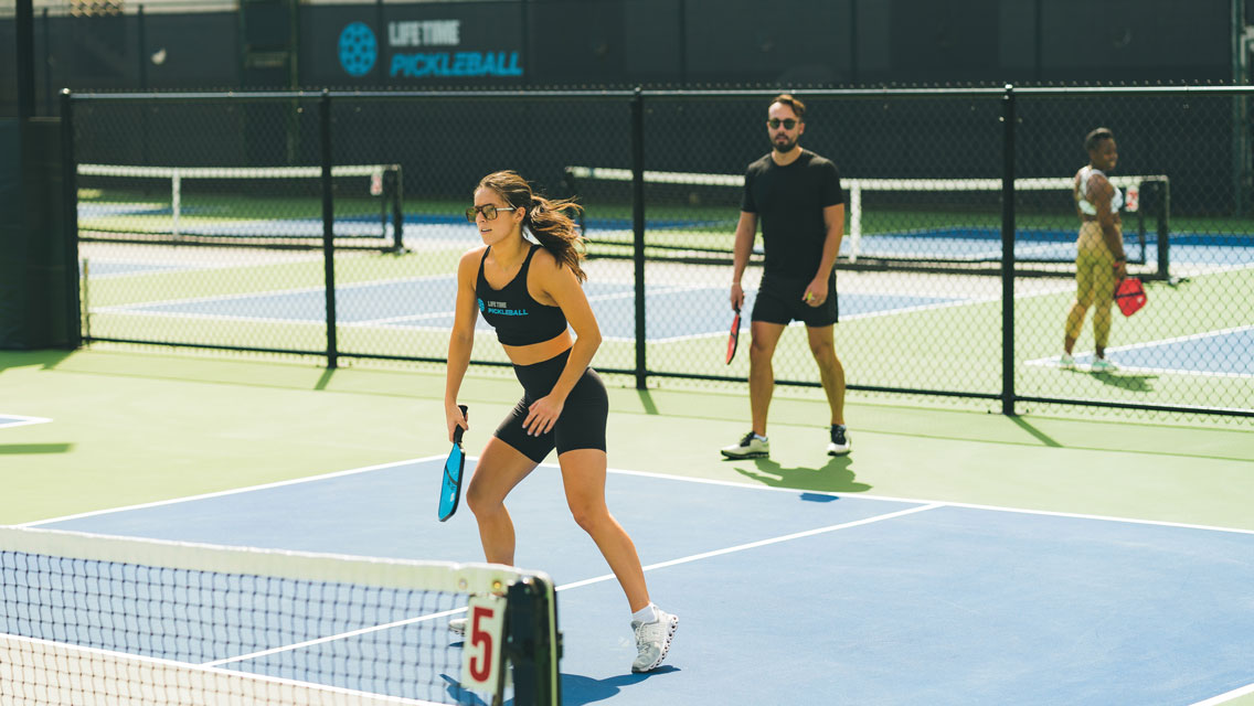 A man and woman playing pickleball together