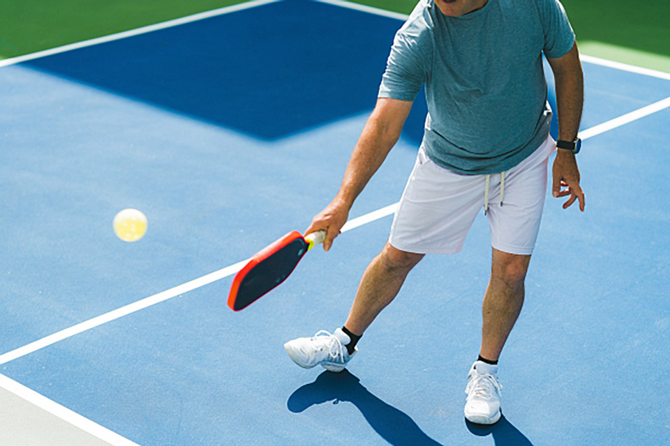 a man hitting a pickleball