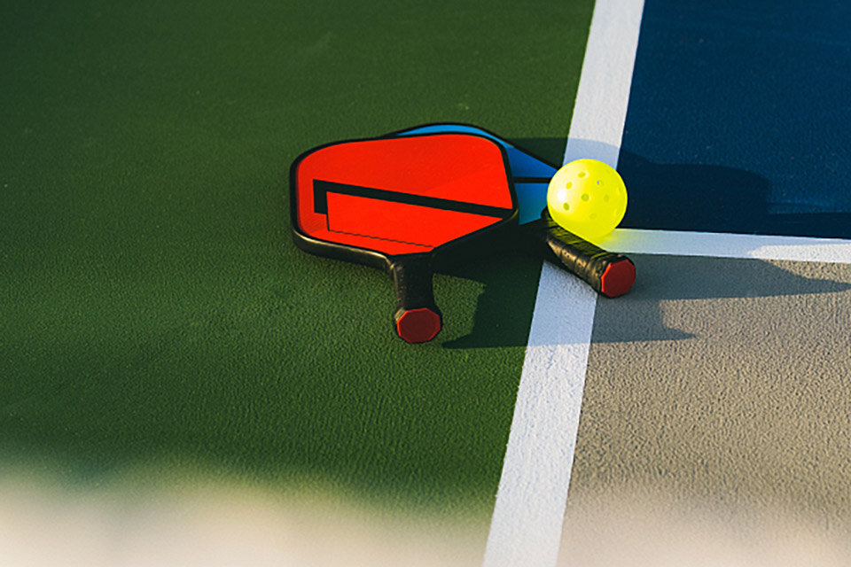 a pair of rackets and a pickleball