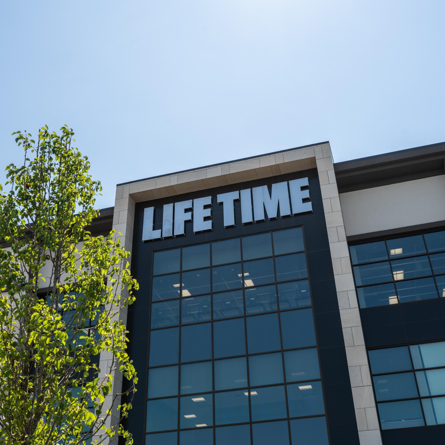 Exterior of a Life Time building with skyscrapers in background.