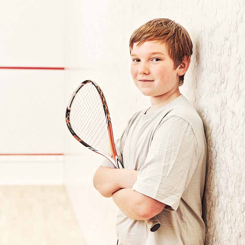 A boy holding a squash racquet
