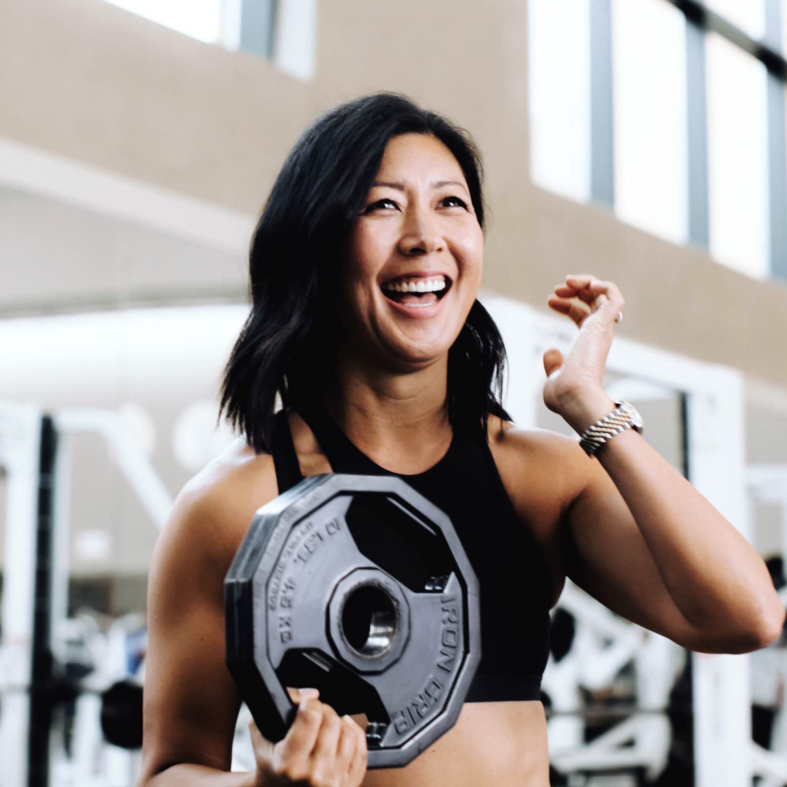 Image of woman holding a weight and laughing