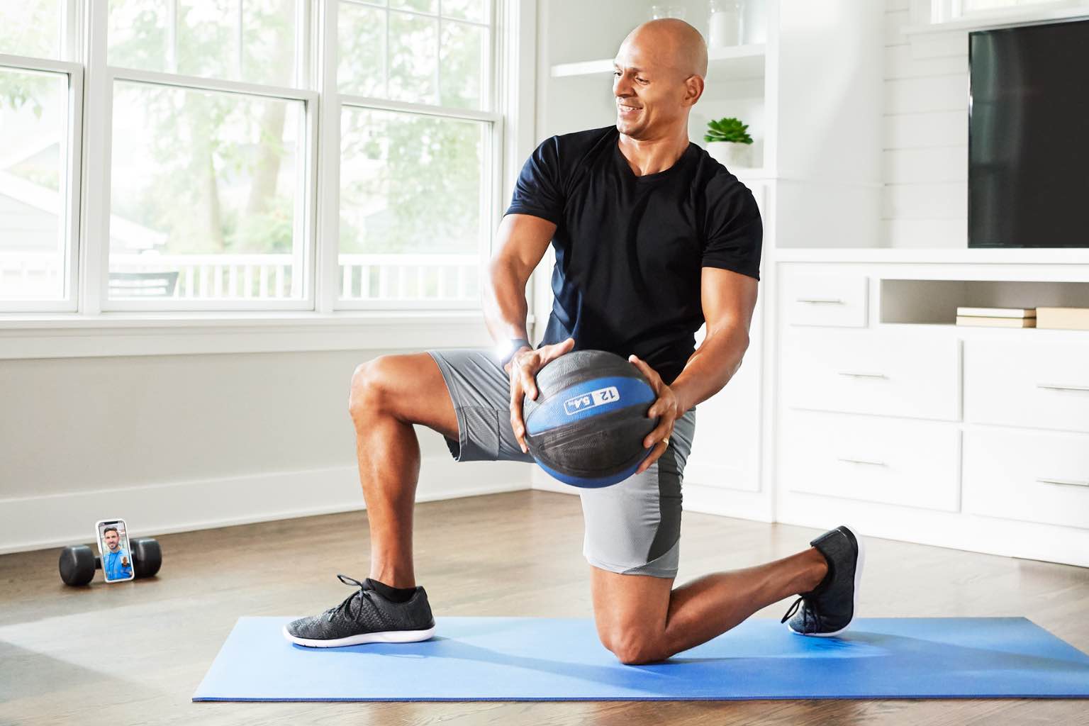 a man does twists with a medicine ball in his living room