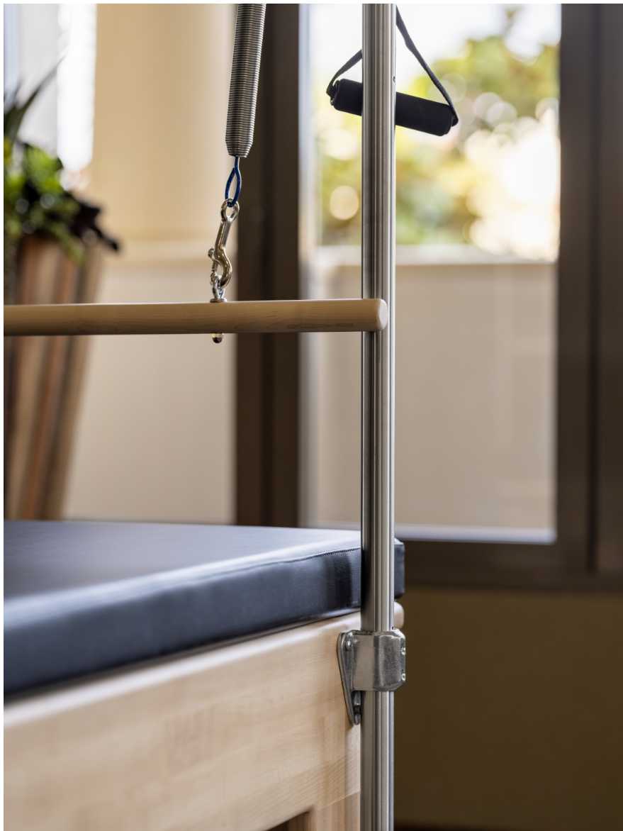 close up of the bars, pulls, and padded bench of the pilates reformer